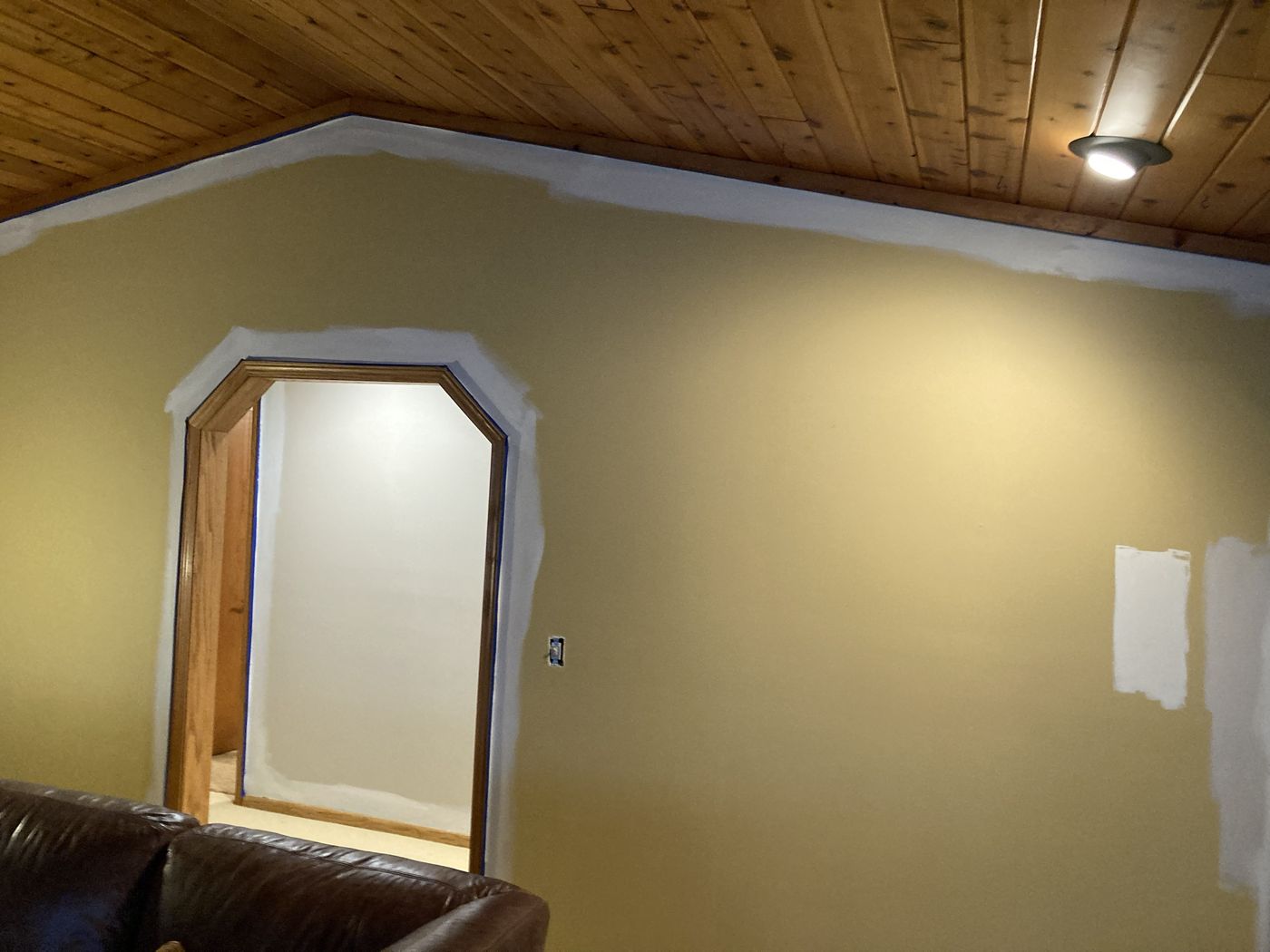 Same wall with the arch taped, a brushed band along the ceiling and color samples